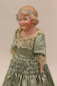 Coquette Doll, 1903-1912
Gebrüder Heubach (1840-1938); Germany
Bisque, paint, satin, lace and…
