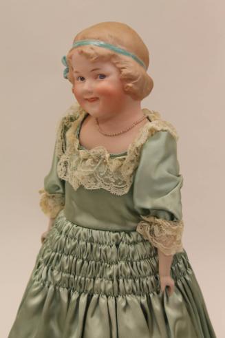 Coquette Doll, 1903-1912
Gebrüder Heubach (1840-1938); Germany
Bisque, paint, satin, lace and…