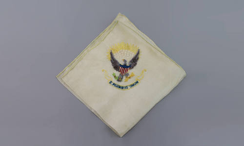 E. Pluribus Unum Handkerchief, mid 20th Century
Maker unknown; France
Fabric; 12 1/2 x 12 1/2…